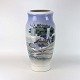 Gulvvase i 
porcelæn med 
motiv af 
stråtægte huse 
i klitmiljø. 
Nr. 2854/131
Producent 
Royal ...