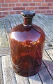 Stor og 
velholdt 
apotekerflaske 
i mørkebrunt 
glas. 
H ca. 31cm - Ø 
ca. 17cm
Indhold: 5 
liter