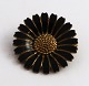Kundby, 
København 
(O.C.K). 
Marguerit 
Broche 
sterlingsølv 
med sort emalje 
(925). Diameter 
3 cm.
