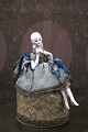 Decorative, old half-doll in porcelain from the 1930s with fine fabric clothing 
sitting on a box...