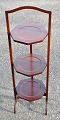 Engelsk cake 
stand i 
mahogni, 19. 
årh. Med tre 
hylder og 
intarsia. 
Sammenklappelig.
 H: 90 cm. B: 
...