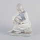 NAO, Spanien.
Porcelænsfigur 
af pige som 
holder hvil. 
Underglasur.
Ca. ...