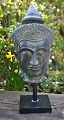 Buddha buste i 
bronze, 20. 
årh. På træfod. 
H: 22,5 cm. H. 
inkl fod: 29,5 
cm. B: 13 cm.