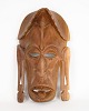 Afrikansk 
maske, 
håndskåret i 
lyst træ, 
typisk for 
traditionelle 
ceremonier og 
ritualer i 
Vest- ...