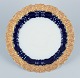 Meissen, Germany. Decorative plate in porcelain, decorated in cobalt blue glaze and gold with ...