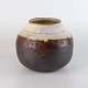 Rund vase i 
keramik med 
brun og lys 
glasur fra år 
1981. Vasen har 
lys glasur på 
indvendig ...