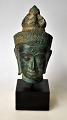 Buddha buste i 
bronze, 20. 
årh. På træfod. 
H.: 13 cm. På 
fod: 19 cm. 