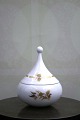 Lille Rosenthal 
Bjørn Wiinblad 
lågkrukke i 
hvid porcelæn 
med guld 
dekorationer. 
H: 11cm. Dia.: 
...