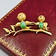 Broche af 14 
kt. guld med 
motiv af to 
fugle på en 
gren. Prydet 
med rubin og 
jade. 
L. 4,7 cm. ...
