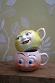 Old children's cups in faience with funny faces.H: 5.5cm. Dia.: 7.5cm. (1 in yellow and 1 in ...