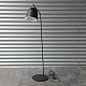 Standerlampe med sortlakeret metalstel og skærm over invendigt hvid plisseret skærm i plast. ...