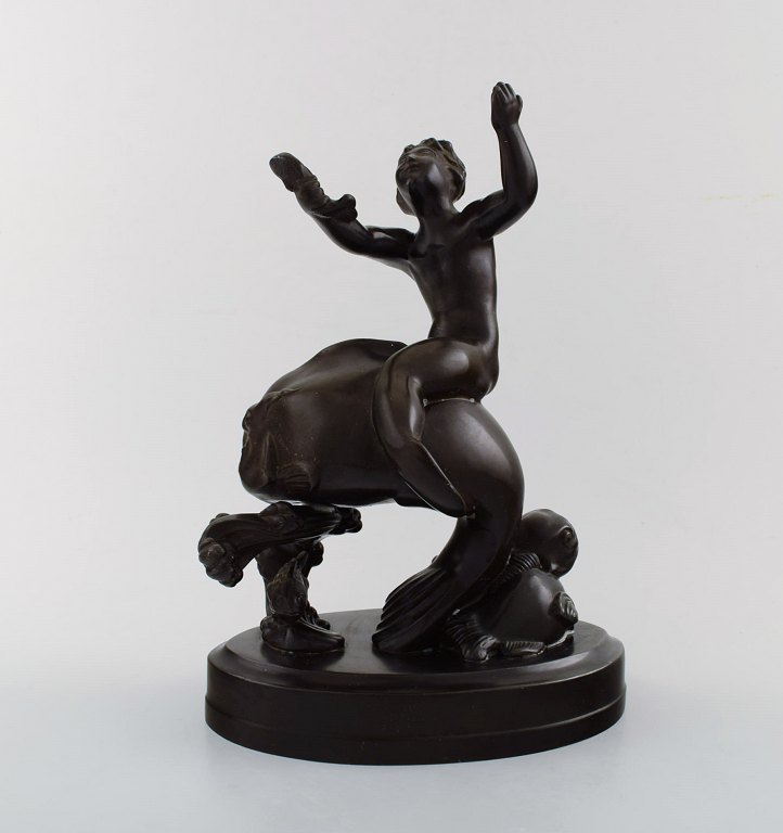 Just Andersen (1884-1943). Figur i disko metal i form af havdreng på fisk.