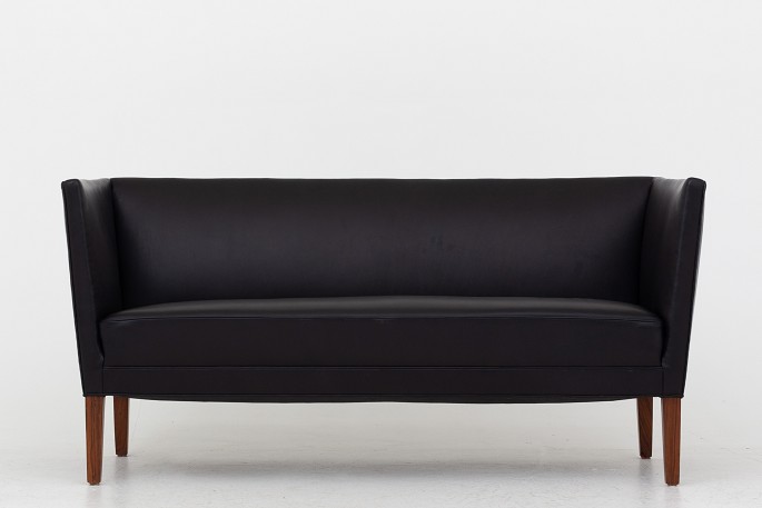 Grete Jalk / Snedkermester Johannes Hansen2 pers. sofa i sort læder og ben i palisander.1 stk. på lagerPæn, brugt stand
