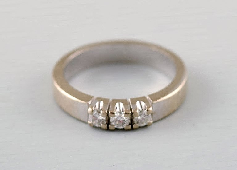 Henning Ulrichsen ring af 14 kt. hvidguld. Prydet med tre brillantslebne 
diamanter (ca 0.24 ct).