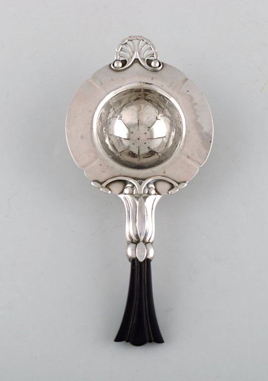 Early and rare art nouveau Georg Jensen tea strainer in silver with ebony 
handle. Dated 1915-30.