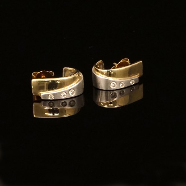 A pair of 14kt gold earrings each with three diamonds of circa 0,04ct. Size: 
14x6mm