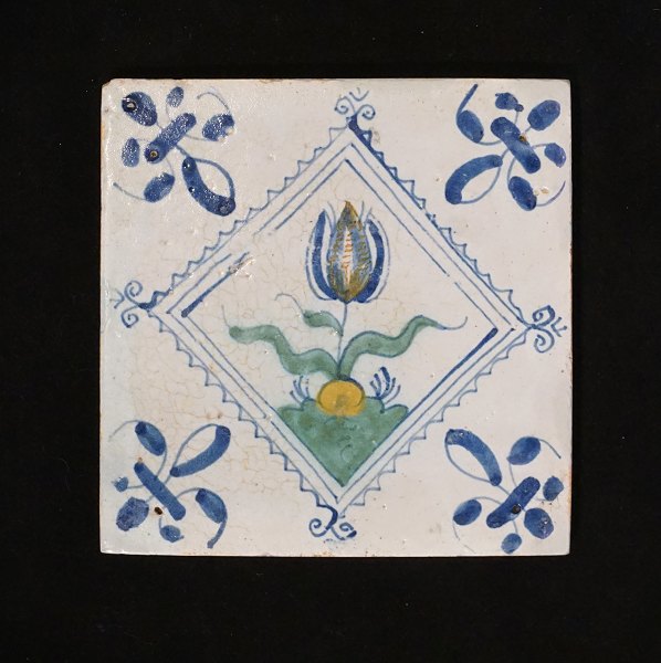 Polychromdekorierte holländische Flise mit Tulpenmotiv. Um 1620-40. Grösse: 
13x13cm