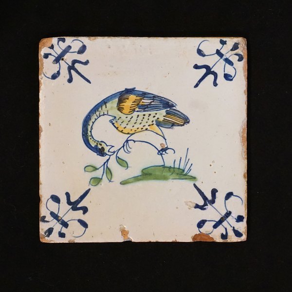 A 17th century polychrome decorated tile with a bird. Circa 1620-40. Size: 
13x13cm