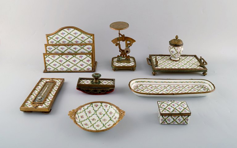 Sevres/Limoges stil. Skrivebordsgarniture i håndmalet porcelæn og messing. 
Tidligt 1900-tallet. Brevvægt, brevholder, blækhus, blæksuger, pennebakke m.m.
