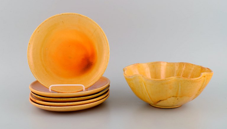 Kähler, HAK. Five plates and bowl in glazed stoneware. Beautiful yellow uranium 
glaze. Mid-20th century.
