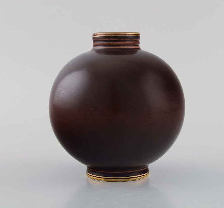 Art deco Rörstrand vase i glaseret keramik. Smuk okseblodsglasur og håndmalet 
gulddekoration. Midt 1900-tallet.
