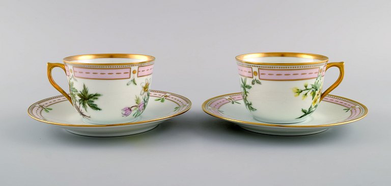 To Bing & Grøndahl kaffekopper med underkopper i håndmalet porcelæn. Blomster og 
gulddekoration. Flora Danica stil, 1920/30