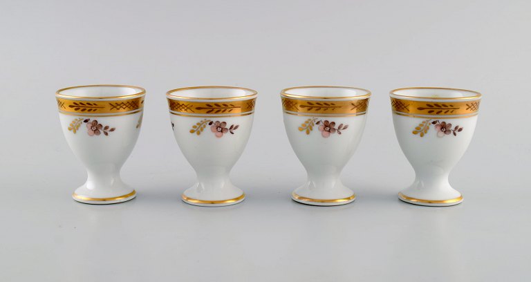 Fire Royal Copenhagen Guldkurv æggebægre i porcelæn med blomster og 
gulddekoration. Modelnummer 595/9110. Tidligt 1900-tallet.
