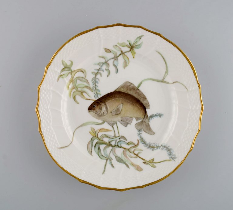 Royal Copenhagen porcelain lunch plate with hand-painted fish motif and golden 
border. Flora / Fauna Danica style. Dated 1965.
