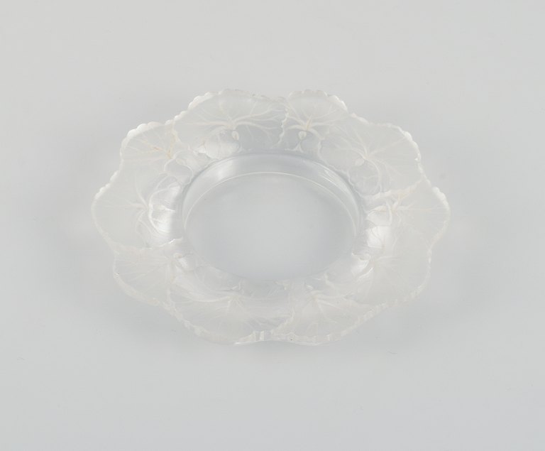 Lalique flaskebakke i klart kunstglas med blomsterdekoration.
Ca. 1980.