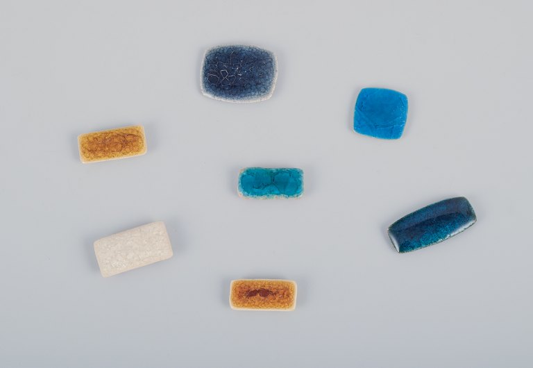 Ole Bjørn Krüger (1922-2007), Danish sculptor and ceramicist.Seven unique brooches in glazed stoneware in blue, brown, and white shades.