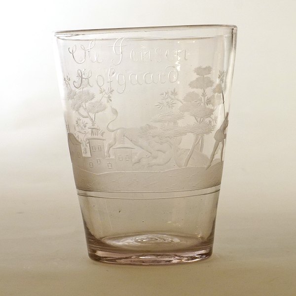 Rigt dekoreret olielampe glas indgraveret med navnet "Ole Jensen Hofgaard" og landskab med huse, træer og løvejagt. Ca. år 1740. H: 12,2cm