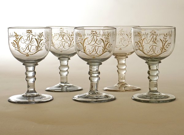 Sæt på fem norske bryllupsglas med forgyldte monogrammer "AF" & "AJ" og drikkevers. Gjøvig Glasværk, "Vinglas med 2de Knapp" ca. år 1810-20. H: 10,5cm